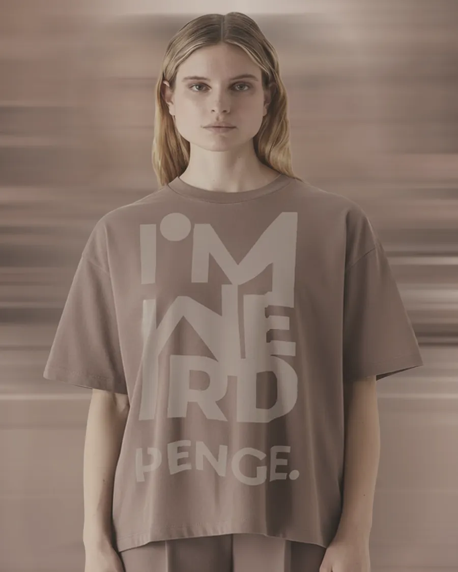 Model standing still in the taupe IMWEIRD tee